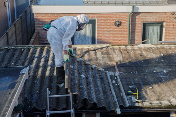 asbestos contractor removing contaminated roofing materials